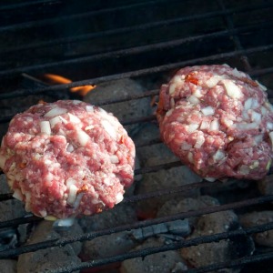 Burgers cooking over charcoal