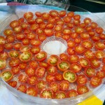 Arrange halved tomatoes on trays
